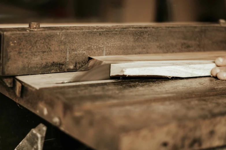 a hand holding onto the edge of a wooden table