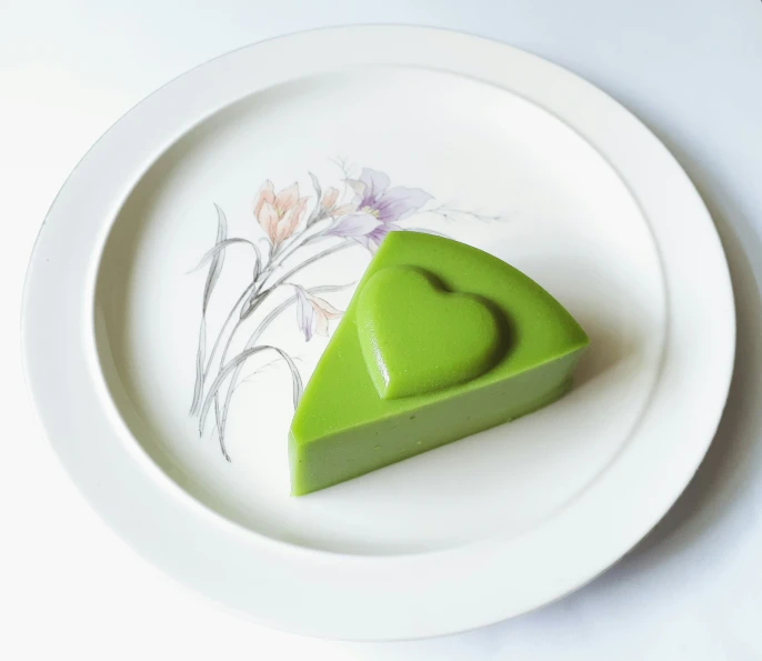 a piece of green cake sitting on top of a white plate