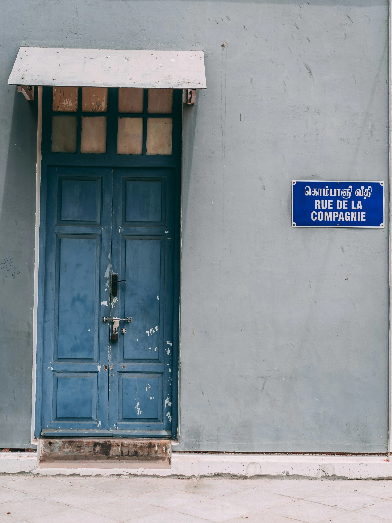 a blue door in front of a grey wall