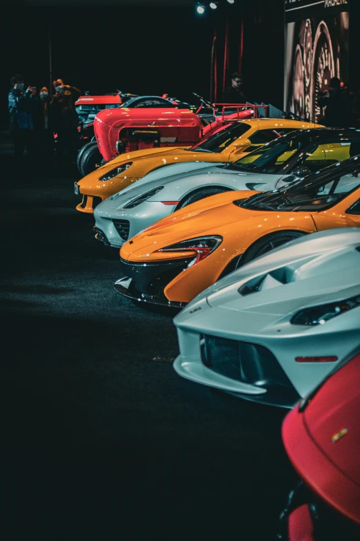 several different colored cars in rows at an event