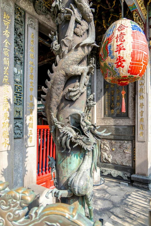 a dragon sculpture sits in front of an oriental building