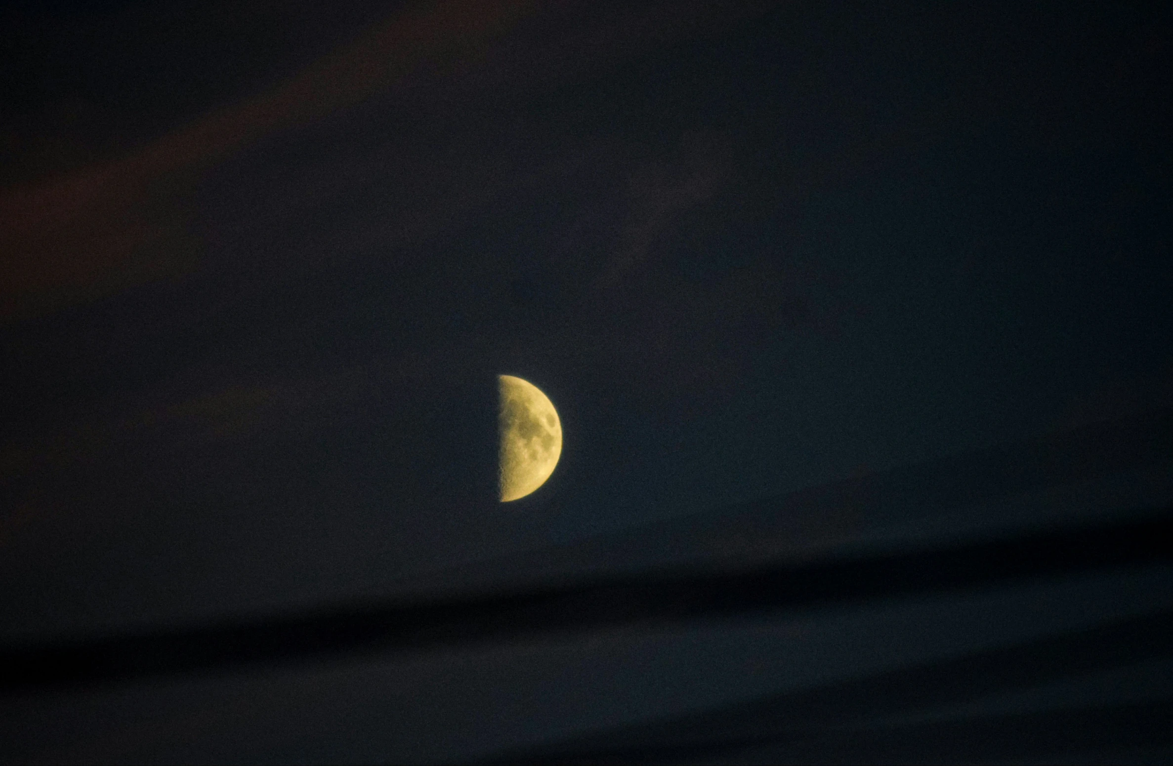 half moon in dark night sky seen from far away