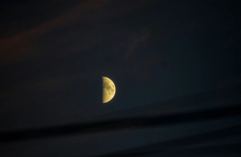 half moon in dark night sky seen from far away