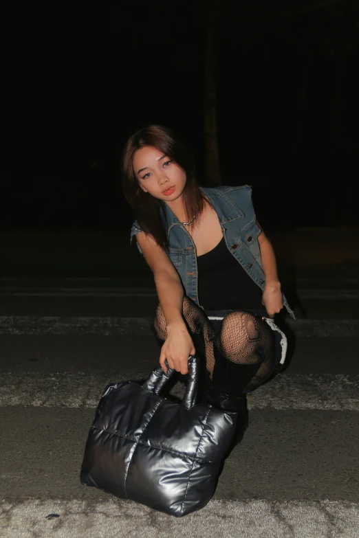 woman sitting on top of a black bag