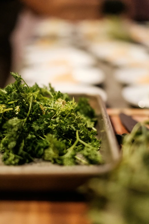 many green vegetables are on a tray sitting on the table