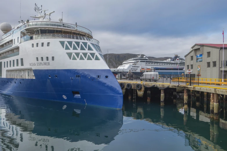 a cruise ship docked in the water by a pier