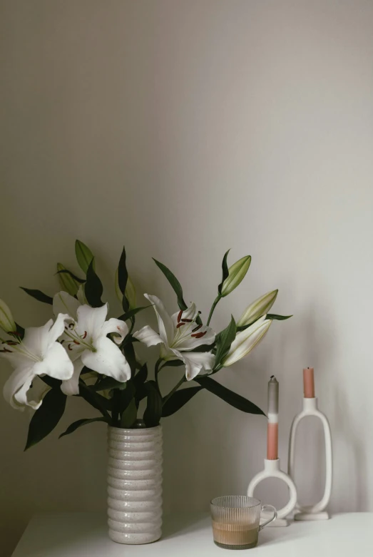 a white table with three vases and several bottles