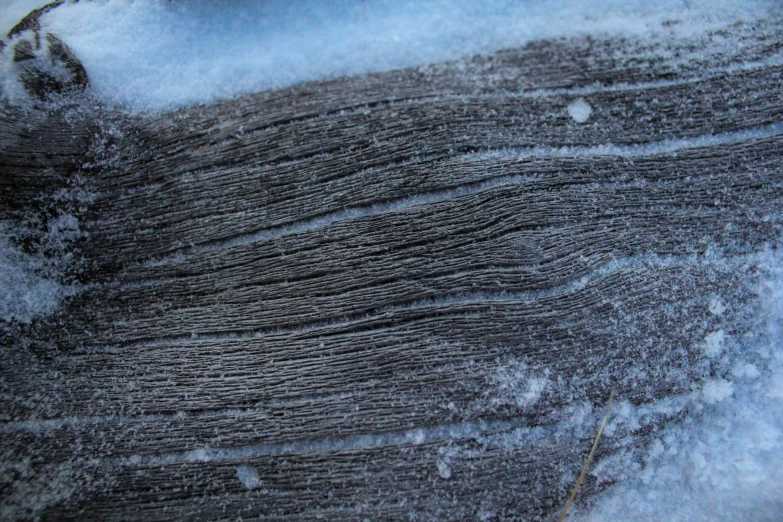 snow that is covering a piece of wood and ice