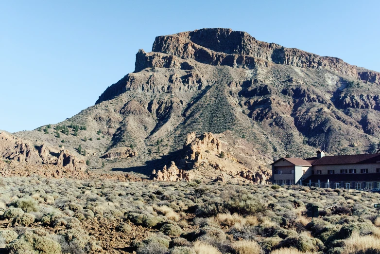 a large building in front of the side of a mountain