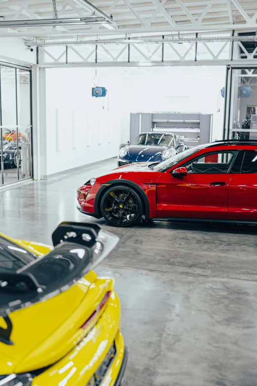 two ferraris are parked in a garage, both have black tires