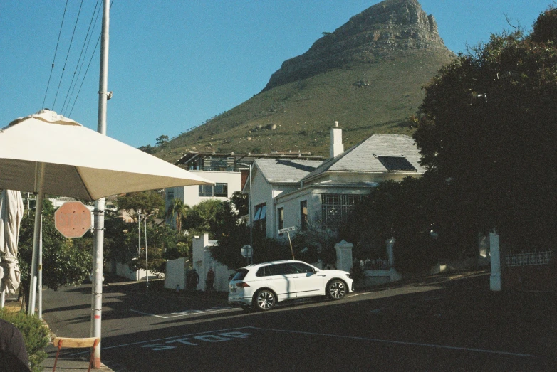 car parked on street in front of small white buildings