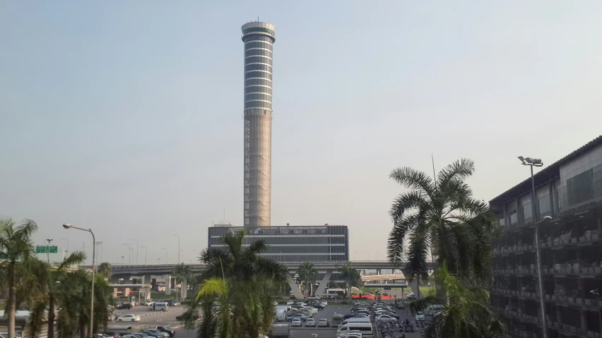 a tall tower sitting above a city filled with palm trees