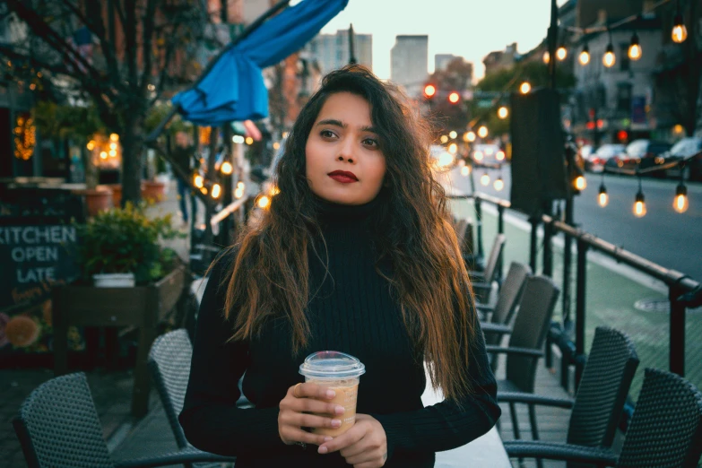 a woman with long, curly hair sitting outside