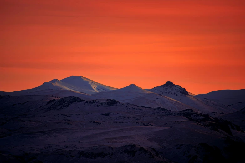 a mountain is seen at sunset with the sun set