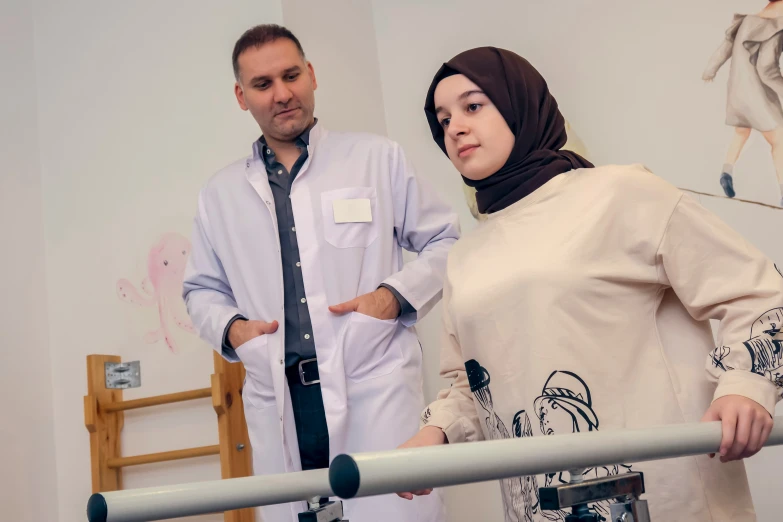 a man and woman wearing a hijab looking at soing