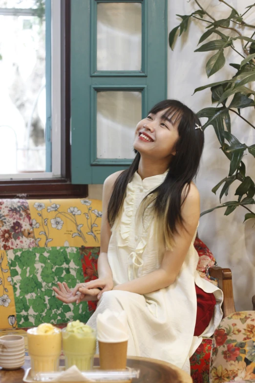 young woman sitting on floral print chair and smiling