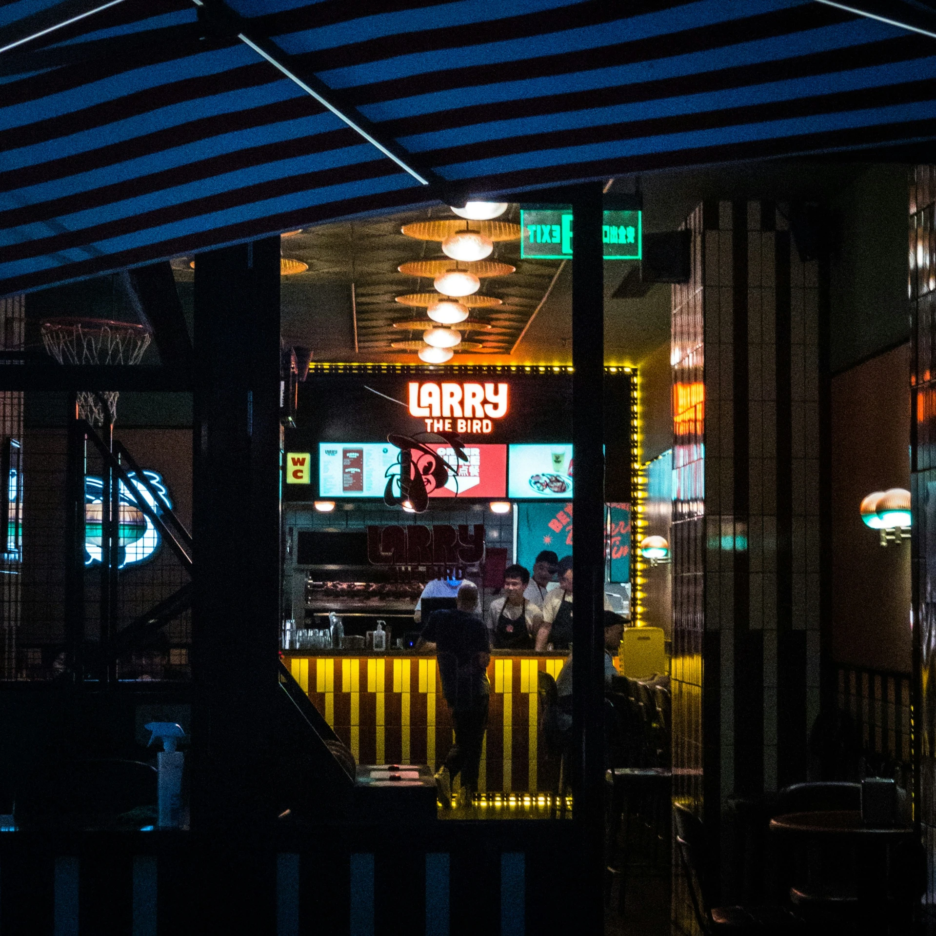 this is the inside of a bar that has stripes and people at it