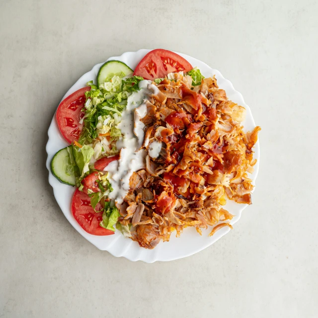 a salad with dressing and mixed vegetables on a white plate