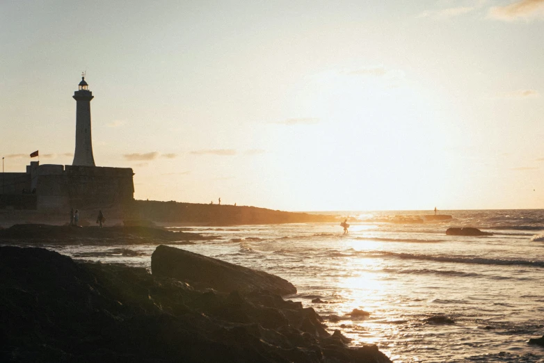 the view of lighthouses on a beach at sunset