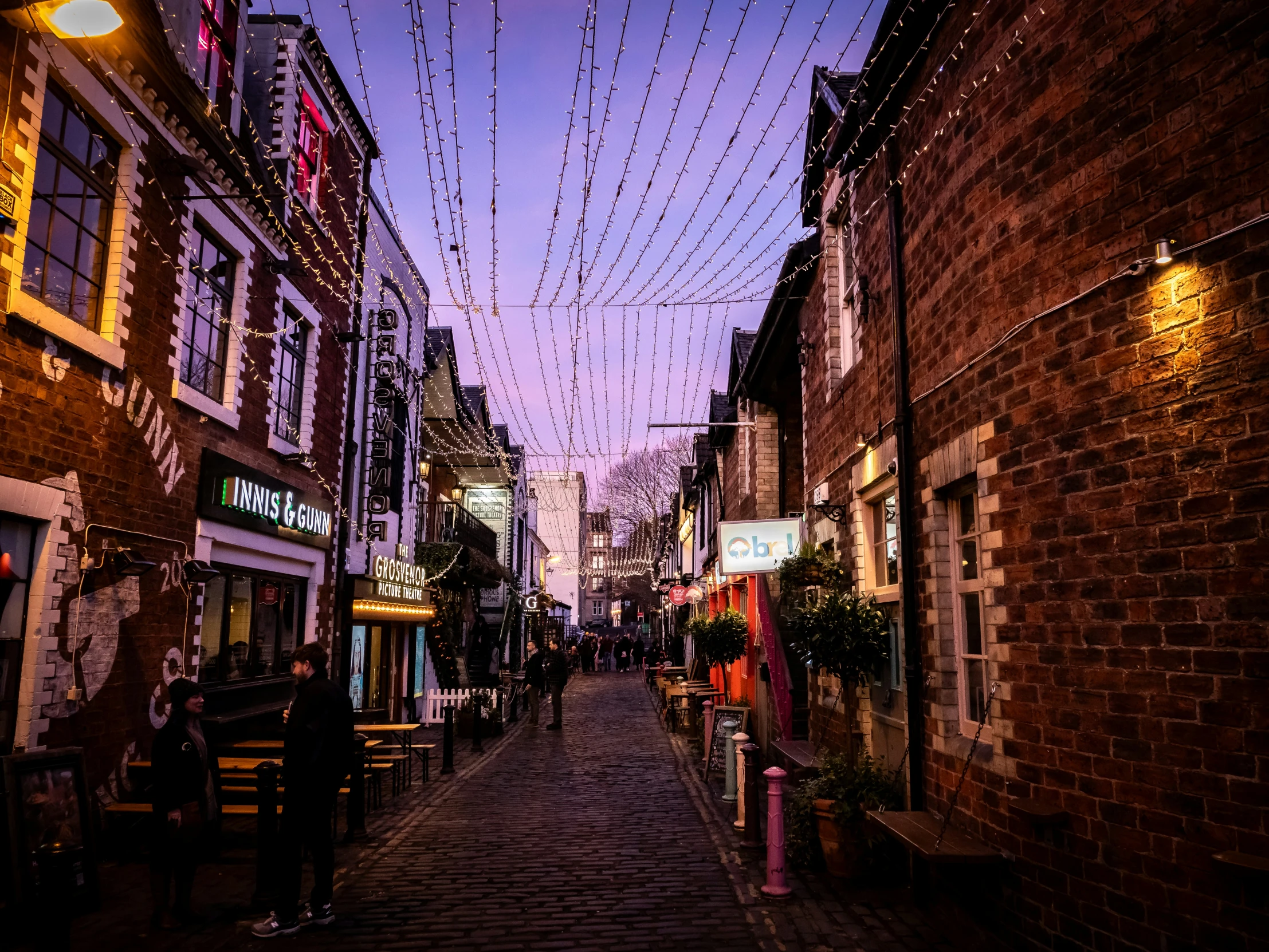 there is a street with people walking down it