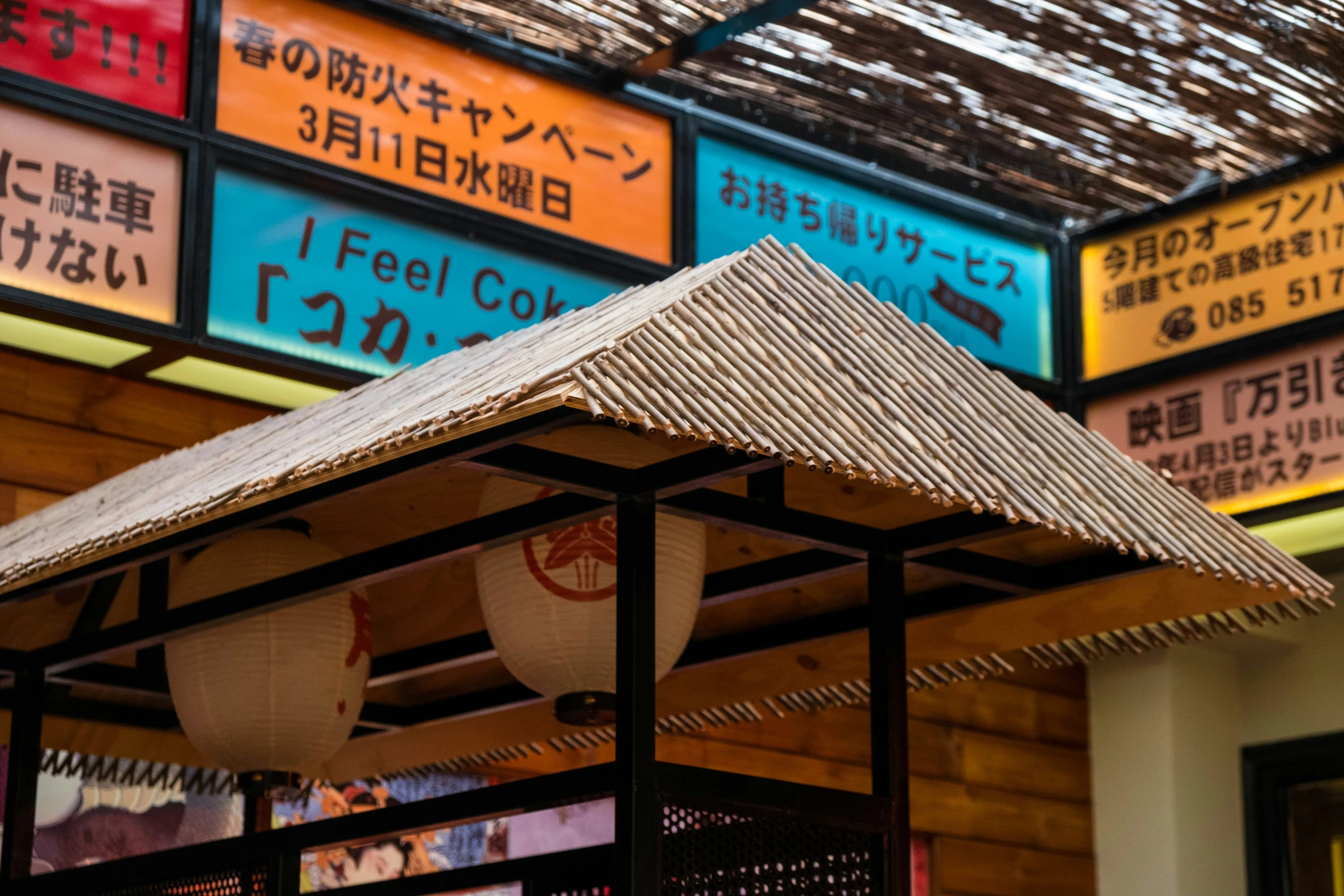 there are colorful signs above a building that has metal roof