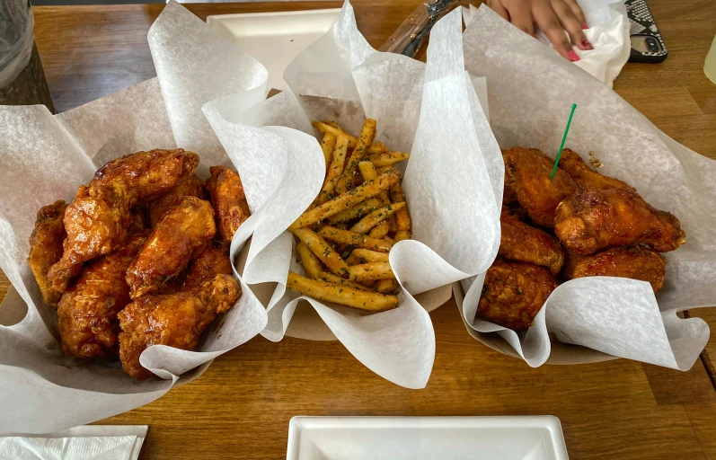 several baskets of food that include fried chicken and fries