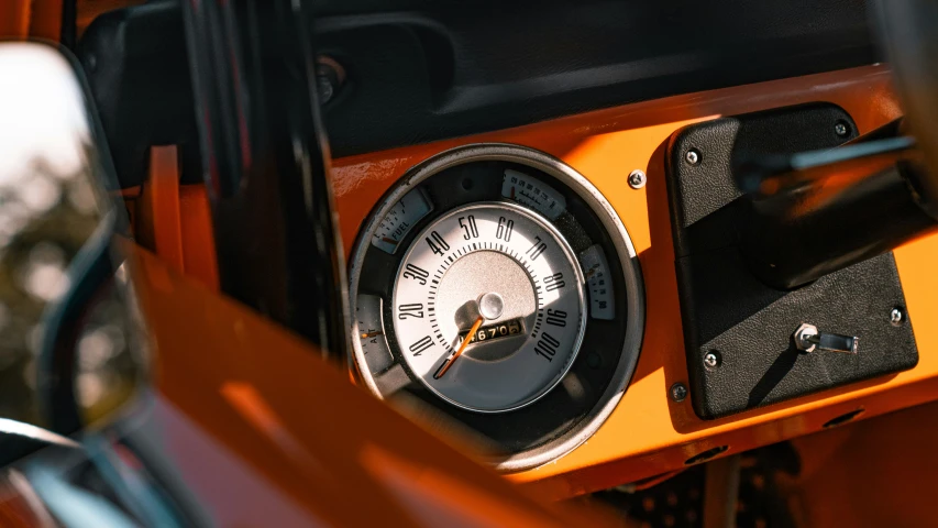 the dashboard of a car with a clock is reflected in the mirror